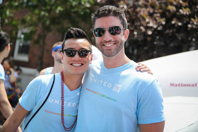 Two men wearing sunglasses and smiling, with their arms around each other.