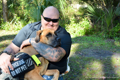 Sergeant First Class U.S. Army (Ret.) Joe Swoboda embraces his service dog Lily.