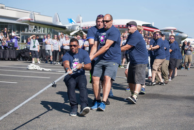 Russell Wilson and his team defeated actor and comedian Joel McHale during the Alaska Airlines Plane Pull benefiting Strong Against Cancer at the Museum of Flight in Seattle on Tuesday, July 28, 2015. Team Wilson pulled the 737 in 16.9 seconds, with Team Joel coming in at over a minute. (AP images)