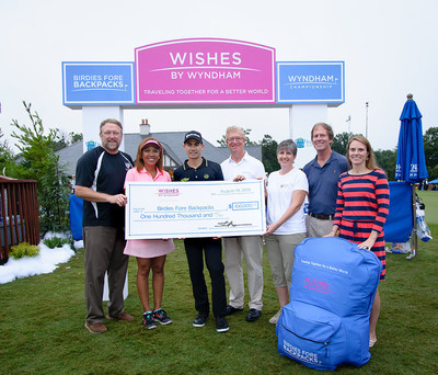 Stephen P. Holmes, chairman and chief executive officer; and Faith Taylor, senior vice president, corporate social responsibility at Wyndham Worldwide, present a check for $100,000 to Birdies Fore Backpacks from the Company's Wishes by Wyndham Foundation. Birdies Fore Backpacks is the official charity of the Wyndham Championship, and supports charitable organizations which fill backpacks with nutritionally sound meals for low income kids and families to take home every weekend...