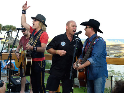 Fan Kenny Waller (center) of Longmont, Colorado signs with Big Kenny and John Rich of Big and Rich at the Holiday Inn Resort on August 23, 2015 in Pensacola, Florida. (Photo by Rick Diamond/Getty Images for Holiday Inn Resort)