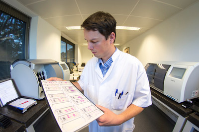 Lab technician reviews tissue slides for scanning