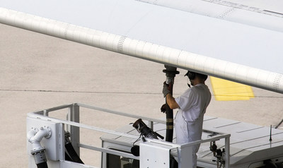 Airline workers re-fueling jet plane.