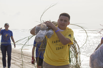 A CITGO volunteer carries some of the 65,000 dune grass plugs planted on Constance Beach, Louisiana