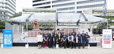 Volunteers from the New Orleans Chapter of Second Harvest Food Bank all pose by the world's largest Carnival cruise ship made out of cans, sponsored by Carnival Cruise Line near Poydras Street side of the Mercedes-Benz Superdome in New Orleans on Monday, December 21, 2015.  (Photo by Peter G. Forest)