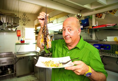 Host Andrew Zimmern holds up his freshly caught Caribbean rock lobster in Guadeloupe