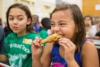 Yum! Elementary school student at a Des Moines public school enjoying a sustainably sourced drumstick.