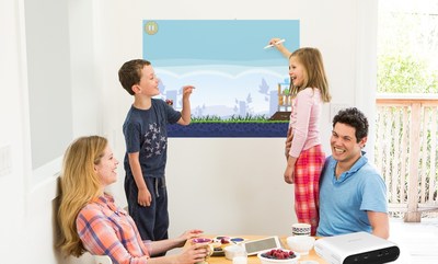 A family playing games and collaborating with the Touchjet Pond Projector on their kitchen wall.