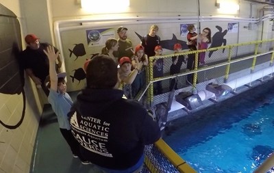 Families of injured service members tour behind the tanks at Adventure Aquarium.