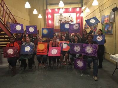 Ladies Night Painting attendees proudly display their vibrant, individual takes on the theme: Moonlight Cherry Blossoms.