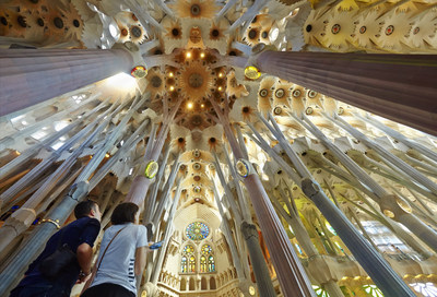 Couple admiring the elaborate, almost stalactite structure that defines the dramatic impact of the Sagrada Familia Temple ceiling by Antoni Gaudi in Barcelona that is featured in the new Michelin Map & Guide travel series. credit: Facto Foto
