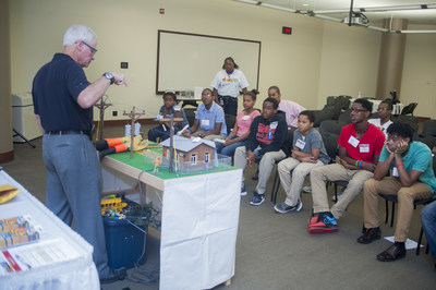 A Georgia Power PowerTOWN presenter talks to students about electrical safety using a model table town. The company has hosted more than 1,000 presentations over the past year.