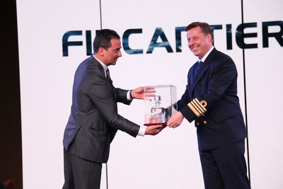 Antonio Quintano, shipyard director for Italian shipbuilder Fincantieri (left), presents Captain Emiel de Vries of Holland America Line's Koningsdam, with the bottle containing the first water touched by the new ship, which made its debut in Rotterdam, the Netherlands in May 2016. The bottle is kept on the ship as a sign of good luck.