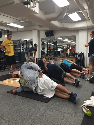 Wounded veterans focus on ab workouts during a group workout with trainers from the University of Michigan Wolverines. The event was sponsored by Wounded Warrior Project (WWP).