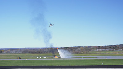 The unmanned K-MAX drops water on a fire during a demonstration at Griffiss International Airport in Rome, New York. The Indago quadrotor identified hot spots and relayed that information to an operator who directed the K-MAX to autonomously retrieve water from a nearby pond and drop it onto the fire. Photo courtesy Lockheed Martin.
